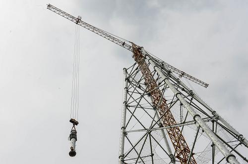 9月26日,施工人员在用吊车吊装铁塔组件.新华社记者 徐昱 摄